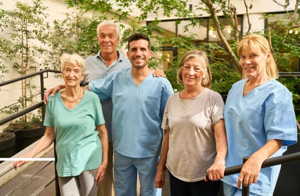 Seniors and caregivers enjoy outdoor time together, demonstrating companionship, compassionate care, and strong partnerships in the industry.