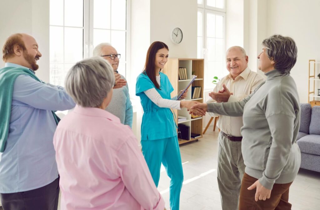 A nurse and a group of smiling seniors at a senior living community.