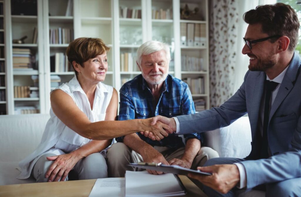 Senior living director shakes hands with a senior, welcoming them to the community.